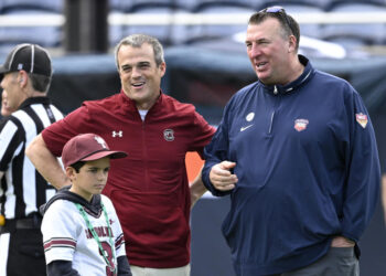 Illinois head coach Bret Bielema, right, and South Carolina head coach Shane Beamer chat on the field before the Citrus Bowl NCAA college football game, Tuesday, Dec. 31, 2024, in Orlando, Fla. (AP Photo/Phelan M. Ebenhack)