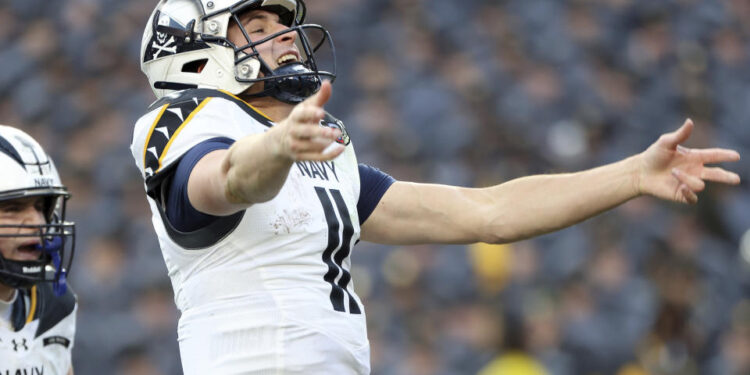 Navy quarterback Blake Horvath (11) celebrates after scoring a touchdown during the first half of an NCAA college football game against Army, Saturday, Dec. 14, 2024, in Landover, Md. (AP Photo/Daniel Kucin Jr.)