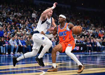 OKLAHOMA CITY, OKLAHOMA - DECEMBER 10: Shai Gilgeous-Alexander #2 of the Oklahoma City Thunder handles the ball in front of Luka Doncic #77 of the Dallas Mavericks during the first half at Paycom Center on December 10, 2024 in Oklahoma City, Oklahoma. NOTE TO USER: User expressly acknowledges and agrees that, by downloading and or using this photograph, User is consenting to the terms and conditions of the Getty Images License Agreement. (Photo by Joshua Gateley/Getty Images)