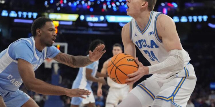 North Carolina's Ty Claude, left, defends UCLA's Tyler Bilodeau, right, during the first half.