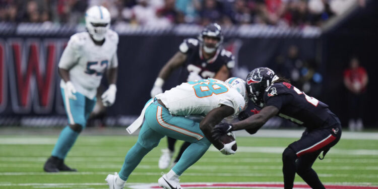 Miami Dolphins wide receiver Grant DuBose (88) is brought down by Houston Texans safety Calen Bullock, right, on a play that left DuBose injured, during the second half of an NFL football game Sunday, Dec. 15, 2024, in Houston. (AP Photo/Eric Christian Smith)