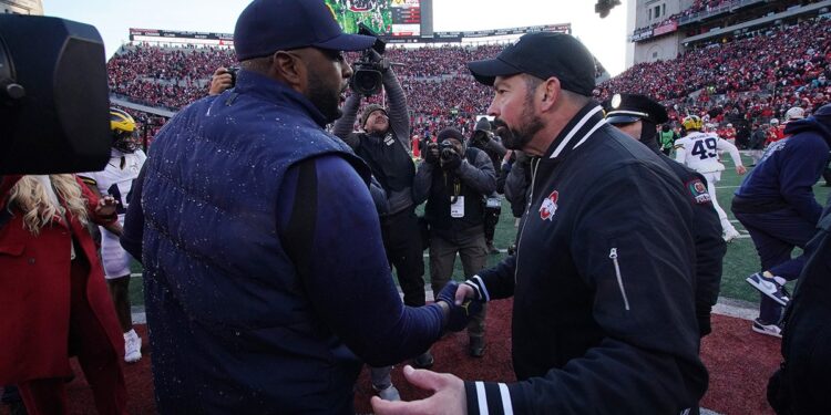 Sherrone Moore shakes hands with Ryan Day