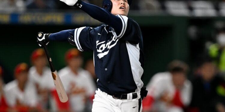 Korea's Hyeseong Kim follows through and looks up while hitting a sacrifice fly during the World Baseball Classic