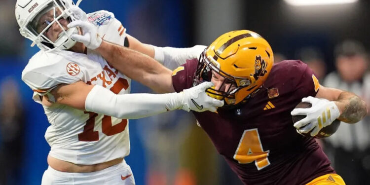 Jan 1, 2025; Atlanta, GA, USA; Arizona State Sun Devils running back Cam Skattebo (4) and Texas Longhorns defensive back Michael Taaffe (16) push each other during the second half of the Peach Bowl at Mercedes-Benz Stadium. Mandatory Credit: Dale Zanine-Imagn Images