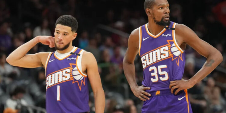 Nov 27, 2024; Phoenix, Arizona, USA; Phoenix Suns guard Devin Booker (1) and Phoenix Suns forward Kevin Durant (35) look on against the Brooklyn Nets during the second half at Footprint Center. Mandatory Credit: Joe Camporeale-Imagn Images