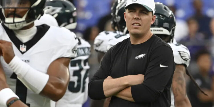 Aug 9, 2024; Baltimore, Maryland, USA; Philadelphia Eagles offensive coordinator Kellen Moore looks on as quarterback Jalen Hurts (1) throws before a preseason game against the Baltimore Ravens at M&amp;T Bank Stadium. Mandatory Credit: Tommy Gilligan-Imagn Images