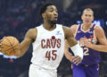 Jan 20, 2025; Cleveland, Ohio, USA; Cleveland Cavaliers guard Donovan Mitchell (45) drives to the basket beside Phoenix Suns center Mason Plumlee (22) in the first quarter at Rocket Mortgage FieldHouse. Mandatory Credit: David Richard-Imagn Images