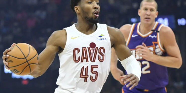 Jan 20, 2025; Cleveland, Ohio, USA; Cleveland Cavaliers guard Donovan Mitchell (45) drives to the basket beside Phoenix Suns center Mason Plumlee (22) in the first quarter at Rocket Mortgage FieldHouse. Mandatory Credit: David Richard-Imagn Images