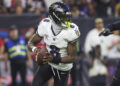 Dec 25, 2024; Houston, Texas, USA;  Baltimore Ravens quarterback Lamar Jackson (8) rolls out of the pocket with the ball during the game against the Houston Texans at NRG Stadium. Mandatory Credit: Troy Taormina-Imagn Images