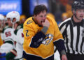 NASHVILLE, TENNESSEE - JANUARY 18:  Luke Schenn #2 of the Nashville Predators checks his teeth after a fight against Marcus Foligno #17 of the Minnesota Wild in the first period on January 18, 2025 at Bridgestone Arena in Nashville. (Photo by Casey Gower/NHLI via Getty Images)