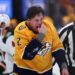 NASHVILLE, TENNESSEE - JANUARY 18:  Luke Schenn #2 of the Nashville Predators checks his teeth after a fight against Marcus Foligno #17 of the Minnesota Wild in the first period on January 18, 2025 at Bridgestone Arena in Nashville. (Photo by Casey Gower/NHLI via Getty Images)