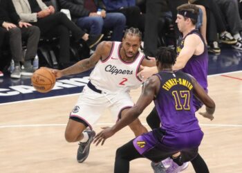 Clippers forward Kawhi Leonard, center, tries to drive past Lakers forwards Austin Reaves, top, and Dorian Finney-Smith