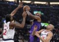 Los Angeles Lakers forward LeBron James, center, shoots as Los Angeles Clippers forward Kawhi Leonard.