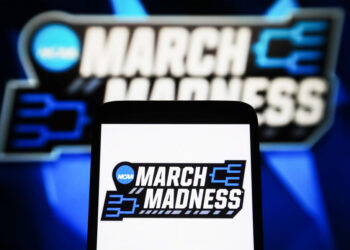 UKRAINE - 2024/04/09: In this photo illustration, a March Madness (NCAA Division I men's basketball tournament) logo is seen on a smartphone and a pc screen. (Photo Illustration by Pavlo Gonchar/SOPA Images/LightRocket via Getty Images)