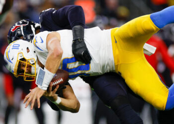 HOUSTON, TEXAS - JANUARY 11: Denico Autry #96 of the Houston Texans sacks Justin Herbert #10 of the Los Angeles Chargers in the third quarter during the AFC Wild Card Playoff game at NRG Stadium on January 11, 2025 in Houston, Texas. (Photo by Brandon Sloter/Getty Images)