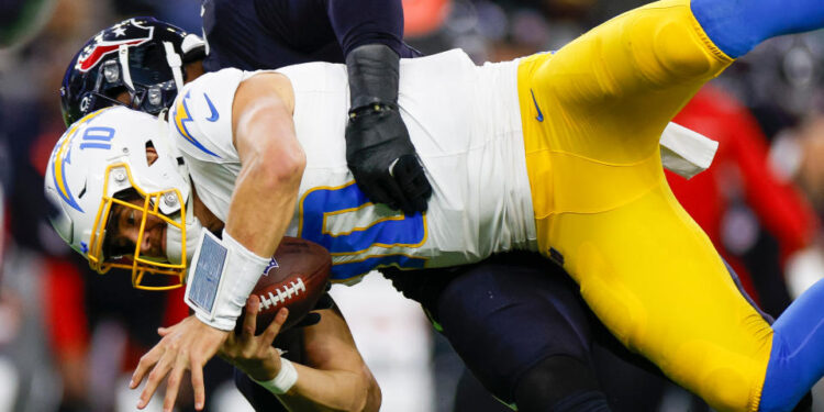 HOUSTON, TEXAS - JANUARY 11: Denico Autry #96 of the Houston Texans sacks Justin Herbert #10 of the Los Angeles Chargers in the third quarter during the AFC Wild Card Playoff game at NRG Stadium on January 11, 2025 in Houston, Texas. (Photo by Brandon Sloter/Getty Images)