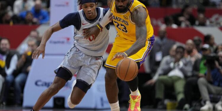 Washington Wizards guard Bilal Coulibaly (0) defends as Los Angeles Lakers forward LeBron James.