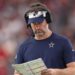 Brian Schottenheimer looks at a play sheet during a Cowboys game