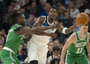 Jan 2, 2025; Minneapolis, Minnesota, USA; Minnesota Timberwolves guard Anthony Edwards (5) passes around Boston Celtics guard Jrue Holiday (4) in the first half at Target Center. Mandatory Credit: Jesse Johnson-Imagn Images