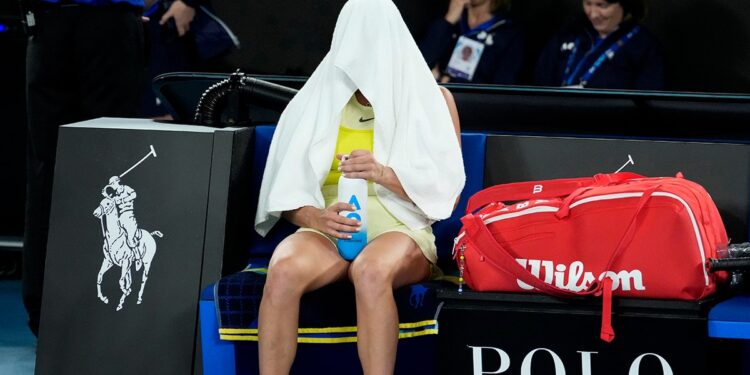 Aryna Sabalenka with towel over head