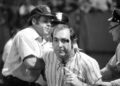 A drunken fan is helped off the field after suffering a minor injury during a game between the Texas Rangers and Cleveland Indians on June 4, 1974, at Cleveland Municipal Stadium.