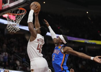 Cleveland Cavaliers guard Donovan Mitchell (45) goes up for a dunk in front of Oklahoma City Thunder guard Shai Gilgeous-Alexander (2) in the first half of an NBA basketball game, Wednesday, Jan. 8, 2025, in Cleveland. (AP Photo/Sue Ogrocki)