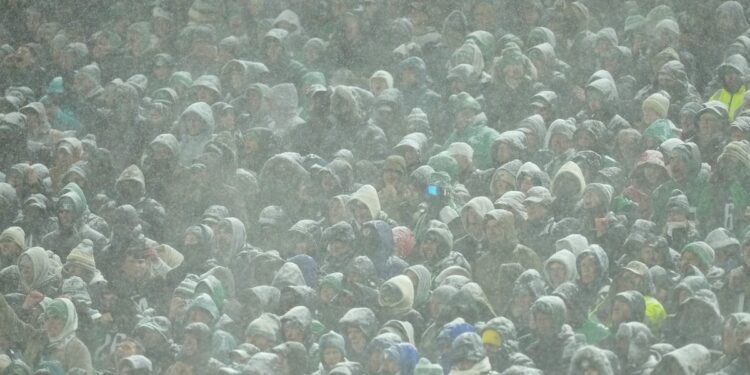 Fans look on in the snow during the fourth quarter between the Philadelphia Eagles and the Los Angeles Rams in the NFC Divisional Playoff at Lincoln Financial Field on January 19, 2025 in Philadelphia, Pennsylvania. 