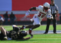 EL PASO, TEXAS - DECEMBER 31: Running back Isaac Brown #25 of the Louisville Cardinals escapes a tackle from linebacker Carson Bruener #42 of the Washington Huskies during the first half of the Tony the Tiger Sun Bowl at Sun Bowl Stadium on December 31, 2024 in El Paso, Texas. (Photo by Sam Wasson/Getty Images)