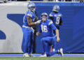 Detroit Lions running back Craig Reynolds (13) helps quarterback Jared Goff (16) up against the Washington Commanders during the first half of an NFL football divisional playoff game, Saturday, Jan. 18, 2025, in Detroit. (AP Photo/Mike Mulholland)