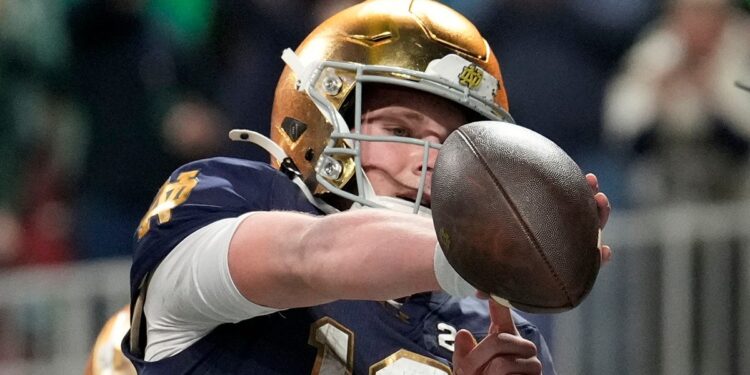 Riley Leonard points to his arm band