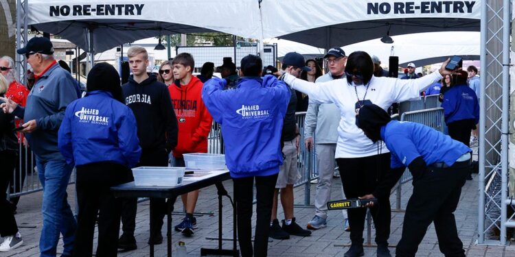 Fans pass through security check points as they enter the Caesars Superdome fan zone ahead of the Sugar Bowl NCAA College Football Playoff game, Thursday, Jan. 2, 2025, in New Orleans. 