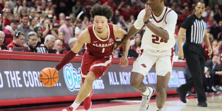 Feb 8, 2025; Fayetteville, Arkansas, USA; Alabama Crimson Tide guard mark Sears (1) drives against Arkansas Razorbacks forward Billy Richmond III (24) during the second half at Bud Walton Arena. Alabama won 85-81. Mandatory Credit: Nelson Chenault-Imagn Images