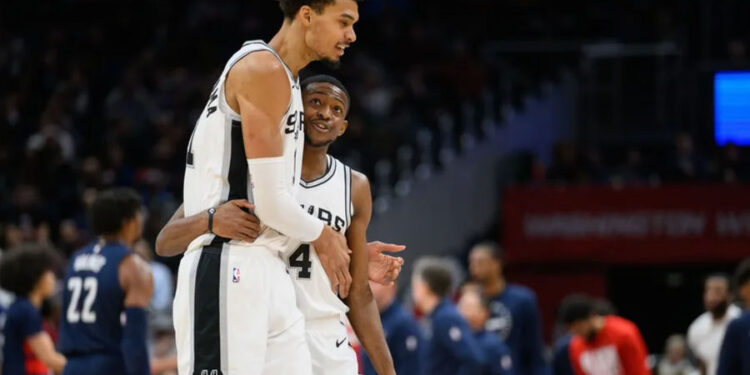 Feb 10, 2025; Washington, District of Columbia, USA; San Antonio Spurs center Victor Wembanyama (1) and guard De'Aaron Fox (4) react during the second quarter against the Washington Wizards at Capital One Arena. Mandatory Credit: Reggie Hildred-Imagn Images