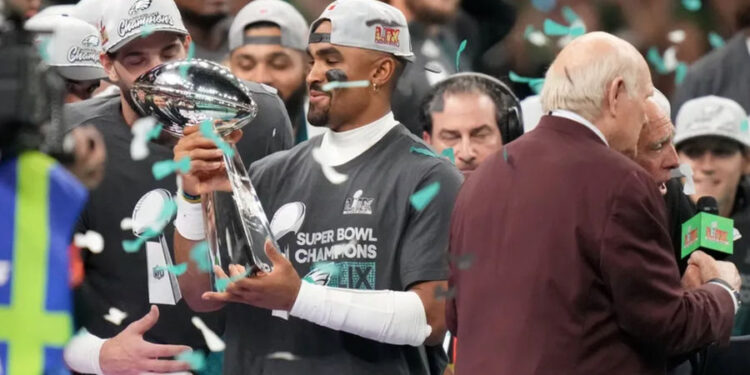 Feb 9, 2025; New Orleans, LA, USA; Philadelphia Eagles quarterback Jalen Hurts (1) hoists the Vince Lombardi Trophy after defeating the Kansas City Chiefs in Super Bowl LIX at Ceasars Superdome. Mandatory Credit: Kirby Lee-Imagn Images