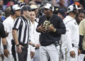 Dec 28, 2024; San Antonio, TX, USA; Colorado Buffaloes head coach Deion Sanders reacts with an official after a play during the second quarter against the Brigham Young Cougars at Alamodome. Mandatory Credit: Troy Taormina-Imagn Images