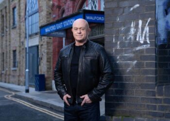 Ross Kemp in character on the EastEnders set, with Walford East Station behind him