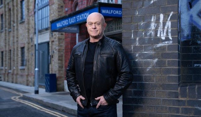 Ross Kemp in character on the EastEnders set, with Walford East Station behind him