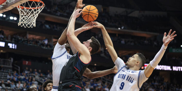 Feb 15, 2025; Newark, New Jersey, USA; Connecticut Huskies forward Alex Karaban (11) goes to the basket asSeton Hall Pirates forward Yacine Toumi (9) defends during the first half at Prudential Center. Mandatory Credit: Vincent Carchietta-Imagn Images