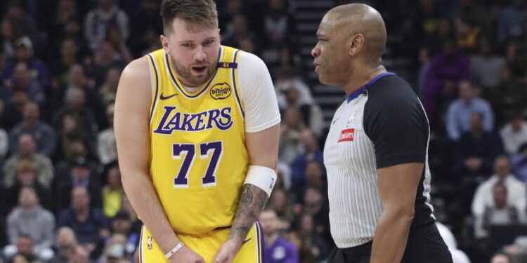 Los Angeles Lakers guard Luka Doncic (77) speaks with referee Tre Maddox (23) about a foul during the second quarter of an NBA basketball game against the Utah Jazz, Wednesday, Feb. 12, 2025, in Salt Lake City. (AP Photo/Rob Gray)