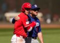 Cincinnati Reds' Gavin Lux, left, hugs Los Angeles Dodgers third baseman Max Muncy.