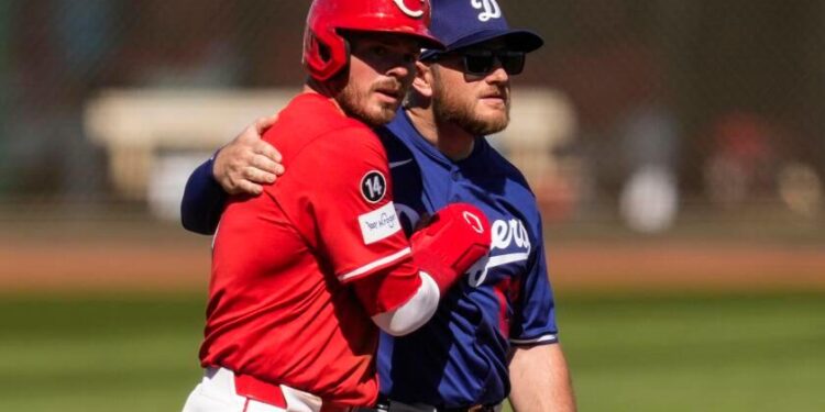 Cincinnati Reds' Gavin Lux, left, hugs Los Angeles Dodgers third baseman Max Muncy.