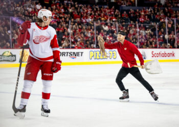 Feb 1, 2025; Calgary, Alberta, CAN; A Calgary Flames ice crew member picks up an octopus that was thrown on the ice during the third period of a game between the Calgary Flames and Detroit Red Wings at Scotiabank Saddledome<p>Brett Holmes&comma; Imagn Images</p>