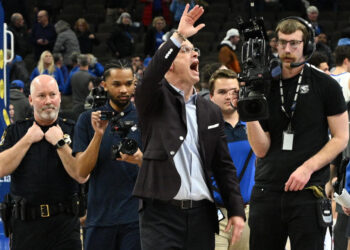 Feb 11, 2025; Omaha, Nebraska, USA;  Connecticut Huskies head coach Dan Hurley waves to the crowd after the win against the Creighton Bluejays at CHI Health Center Omaha. Mandatory Credit: Steven Branscombe-Imagn Images