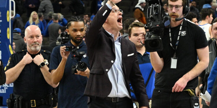 Feb 11, 2025; Omaha, Nebraska, USA;  Connecticut Huskies head coach Dan Hurley waves to the crowd after the win against the Creighton Bluejays at CHI Health Center Omaha. Mandatory Credit: Steven Branscombe-Imagn Images