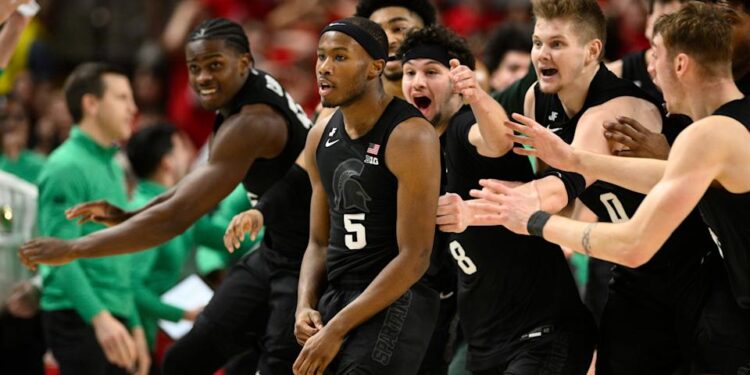 Michigan State guard Tre Holloman (5) and teammates celebrate after he made a game-winning basket to win the game at the buzzer during the second half of an NCAA college basketball game against Maryland, Wednesday, Feb. 26, 2025, in College Park, Md. (AP Photo/Nick Wass)