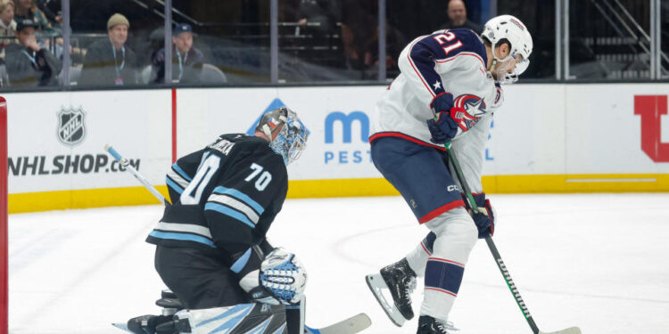 Jan 31, 2025; Salt Lake City, Utah, USA;  Columbus Blue Jackets left wing James van Riemsdyk (21) tries to deflect the puck past Utah Hockey Club goaltender Karel Vejmelka (70) and into the net with his skate during the third period at Delta Center. Mandatory Credit: Chris Nicoll-Imagn Images