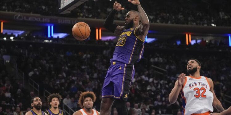 Lakers star LeBron James dunks in front of New York's Karl-Anthony Towns at Madison Square Garden.