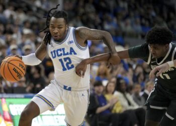 UCLA guard Sebastian Mack (12) dribbles against Michigan State guard Jase Richardson (11) during the second half of an NCAA college basketball game in Los Angeles, Tuesday, Feb. 4, 2025. (AP Photo/Eric Thayer)