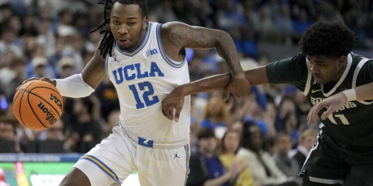 UCLA guard Sebastian Mack (12) dribbles against Michigan State guard Jase Richardson (11) during the second half of an NCAA college basketball game in Los Angeles, Tuesday, Feb. 4, 2025. (AP Photo/Eric Thayer)