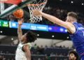 WACO, TX - FEBRUARY 01: Baylor Bears guard Robert Wright III (1) leaps for a reverse layup after driving past Kansas Jayhawks center Hunter Dickinson (1) during the Big 12 college basketball game between Baylor Bears and Kansas Jayhawks on February 1, 2025, at Foster Pavilion in Waco, Texas. (Photo by David Buono/Icon Sportswire via Getty Images)